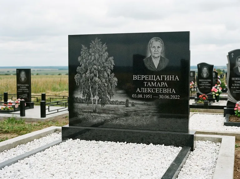 Памятник с гравировкой берёзы: широкая горизонтальная стела — берёза у поля, простор до горизонта, белая мраморная крошка с бордюром, работа «Верещагина» в Оренбурге