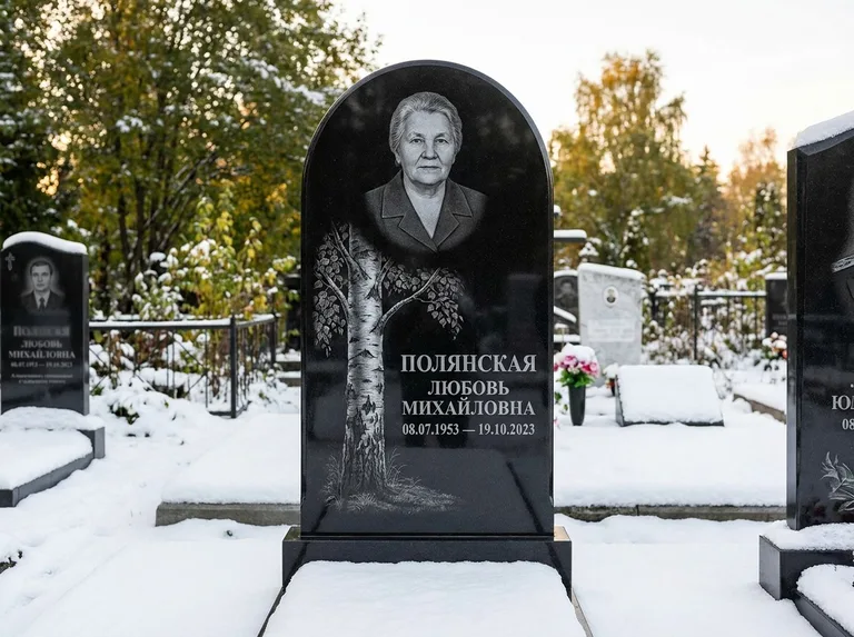 Памятник с гравировкой берёзы: полукруглая стела — объёмная одинокая берёза с фактурной корой, заснеженный зимний участок, работа «Полянская» в Оренбурге