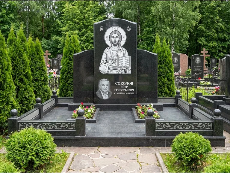 Памятник с гравировкой иконы: широкая горизонтальная лежачая плита-стела — икона в резной рамке-киоте, серая гравийная отсыпка с бордюром, работа «Богданова» в Оренбурге