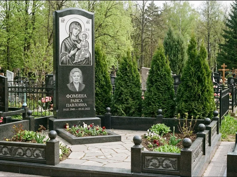 Памятник с гравировкой иконы: высокий гранёный обелиск с крестом-навершием — гравировка образа Матроны Московской, открытый участок без ограды, работа «Третьяков» в Оренбурге