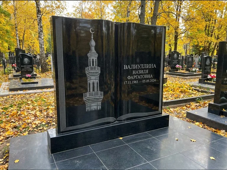 Мусульманский памятник с гравировкой мечети: стела в форме раскрытой книги на подставке — белая гравировка силуэта мечети с минаретами, цоколь тёмной плиткой, работа «Исмаилова» в Оренбурге