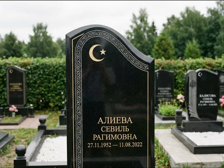 Мусульманский памятник: асимметричная скошенная стела — белая гравировка силуэта мечети с минаретами, живая изгородь из кустарника, работа «Алиева» в Оренбурге