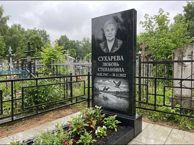 Памятник с гравировкой журавлей — гравировка пары журавлей над гладью озера в нижней части, работа «Сухарева» в Оренбурге