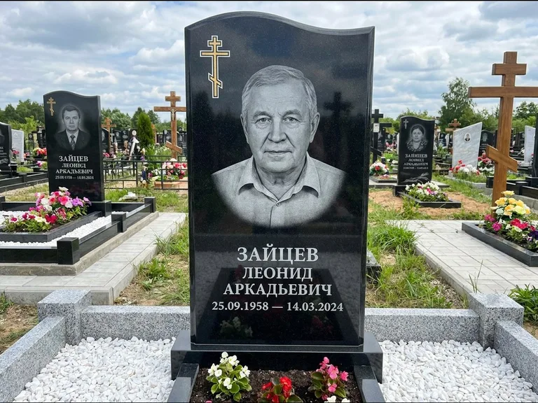 Памятник из чёрного гранита — горизонтальная семейная стела с аркой с процветшим крестом с виноградной лозой, работа «Верещагин» в Оренбурге