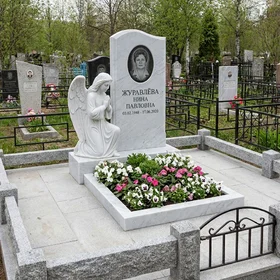 Резной памятник из белого мрамора в виде молящегося ангела
